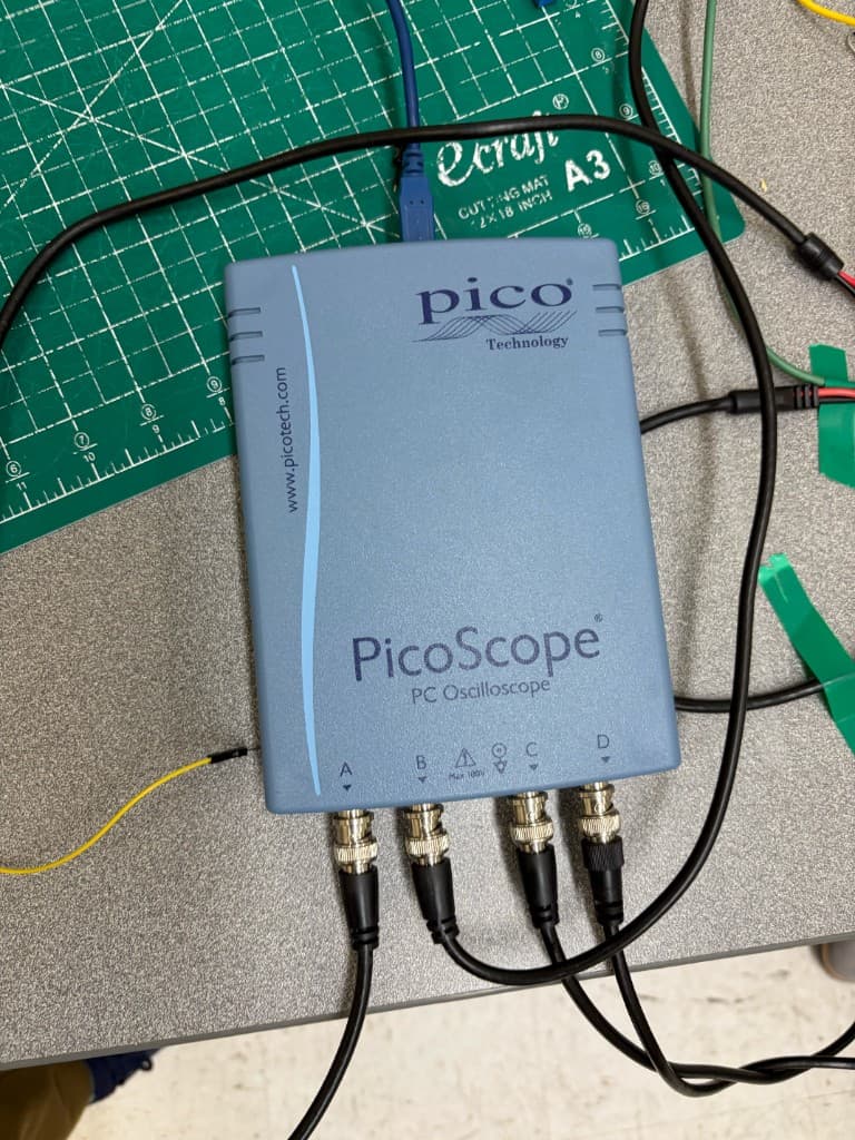 PicoScope PC oscilloscope connected to four BNC input channels on a lab workbench
