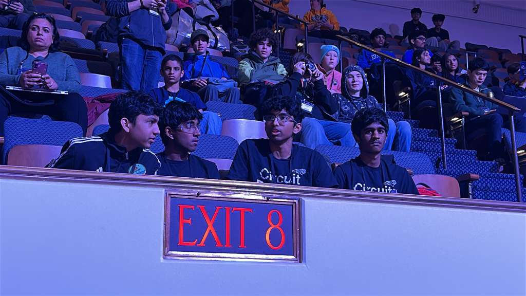 Circuit Breakers team members seated in competition arena stands wearing team shirts