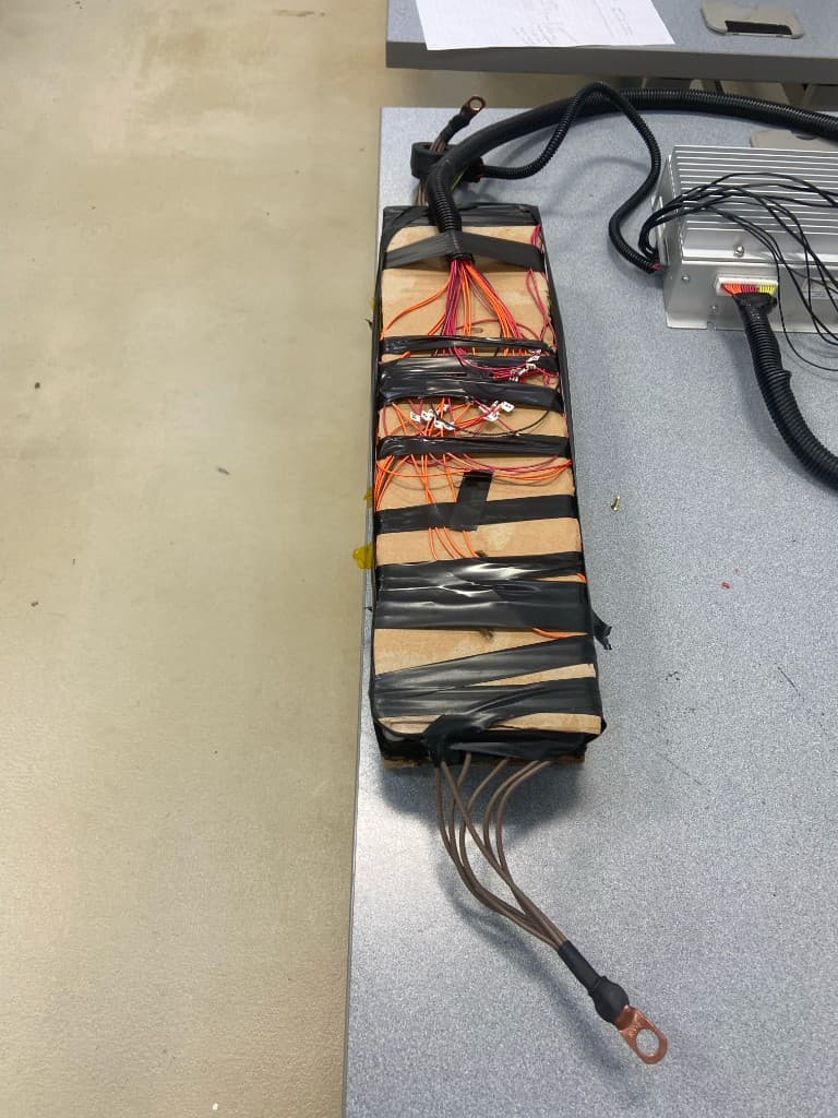 Multi-cell lithium-ion battery pack with balance-lead wiring harness and controller on a lab bench