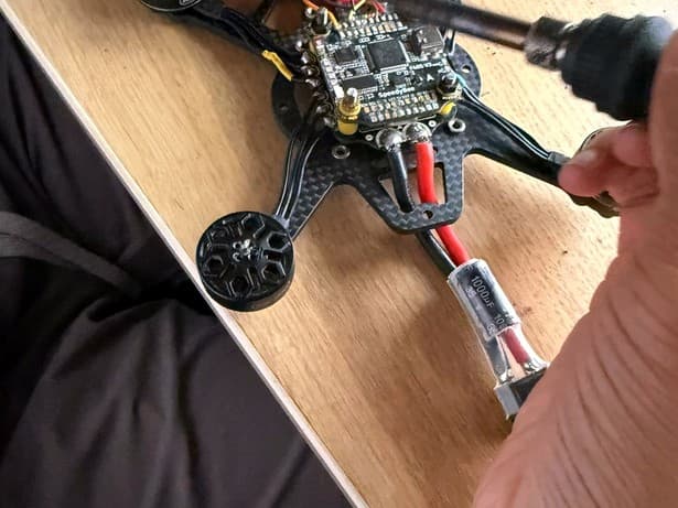Soldering motor wires to a SpeedyBee F405 flight controller on the frame